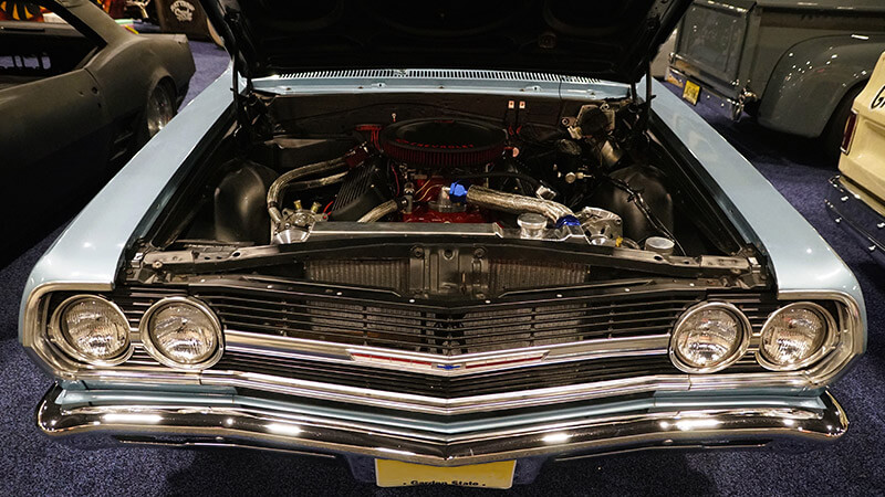 A top-down view of a light blue 1965 Chevy Chevelle's engine bay