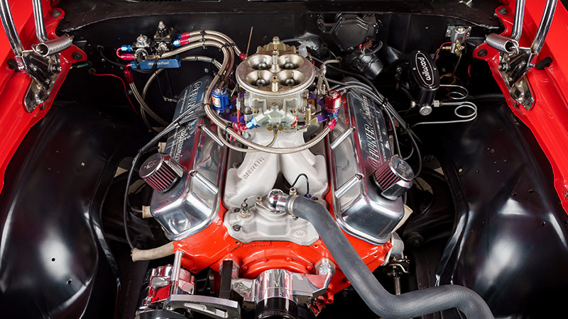 A close up of the engine bay of a classic Chevy Camaro with a restored and upgraded 396 big block engine