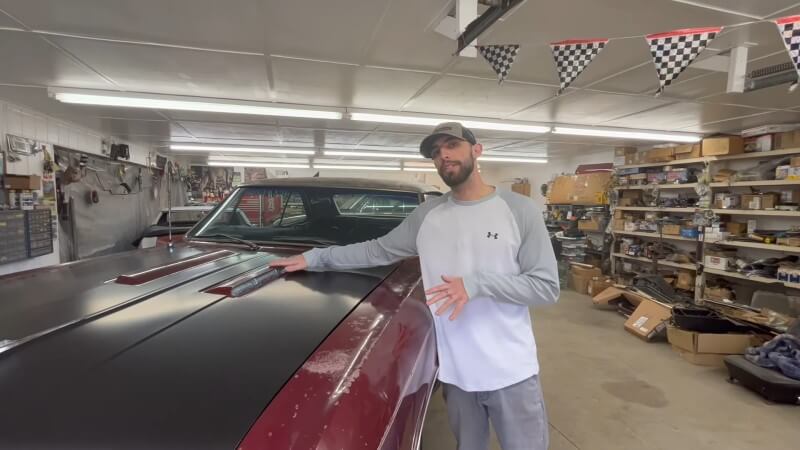 A mechanic pointing at the hood vents on a 1966 Chevelle Super Sport